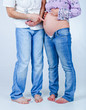 Pregnant couple in jeans. In the studio