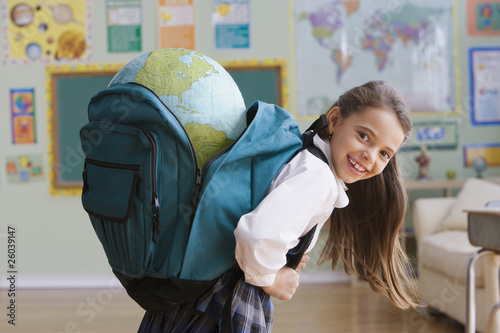 Photo: Hispanic girl carrying large globe in backpack Hispanic girl carrying large globe in backpack