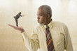 Giant businessman blowing on miniature businessman