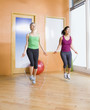 Two women jumping rope in health club