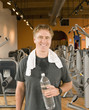 Man with towel and water bottle in health club