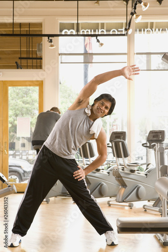 Photo: Pacific Islander man stretching in health club Pacific Islander man stretching in health club