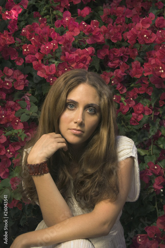Photo: Hispanic woman sitting in front of flowers Hispanic woman sitting in front of flowers