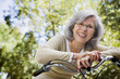 Senior Hispanic woman leaning on bicycle outdoors