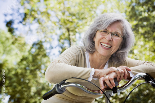 Foto: Senior Hispanic woman leaning on bicycle outdoors Senior Hispanic woman leaning on bicycle outdoors