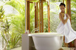 Pacific Islander woman sitting on edge of bathtub