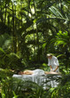 Pacific Islander woman receiving massage in jungle