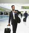 Hispanic businessman checking time in airport