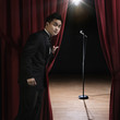 Asian man in tuxedo standing backstage