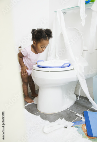 Photo: African American girl looking into toilet African American girl looking into toilet
