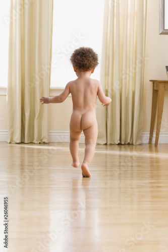 Photo: Naked mixed race boy running in living room Naked mixed race boy running in living room