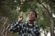 African boy standing in park pointing upwards
