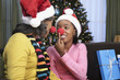 African woman and granddaughter in santa hats and red noses