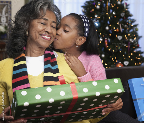 Photo: African girl giving grandmother Christmas gift African girl giving grandmother Christmas gift