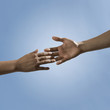Mixed race people reaching out hands toward one another