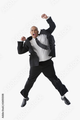 Photo: Hispanic businessman cheering and jumping in air Hispanic businessman cheering and jumping in air