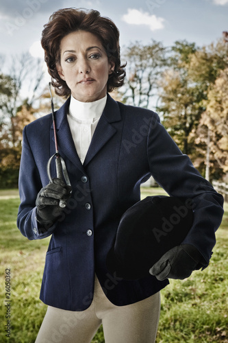 Photo: Hispanic woman wearing riding gear holding hat and crop Hispanic woman wearing riding gear holding hat and crop
