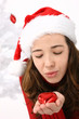woman wearing santa hat holding an heart