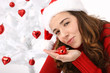 Beautiful young woman wearing santa hat next to christmas tree o