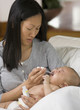 Asian mother giving medicine to baby