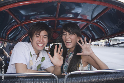 Photo: Asian couple in taxi waving Asian couple in taxi waving