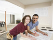 Couple looking at blueprint in kitchen
