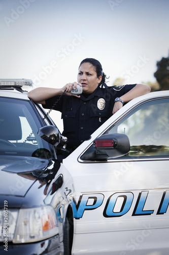 Photo: Hispanic policewoman talking on CB radio Hispanic policewoman talking on CB radio