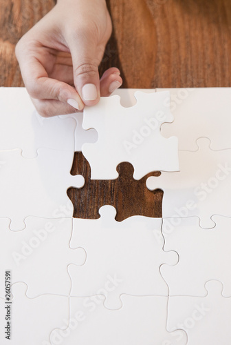 Photo: Woman completing jigsaw puzzle Woman completing jigsaw puzzle