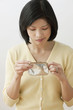 Filipino woman looking into wallet and making a face