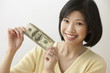 Filipino woman holding one hundred dollar bill
