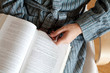 man's in bathrobe hands holding glasses over the book
