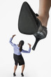 Large high heel looming over businesswoman