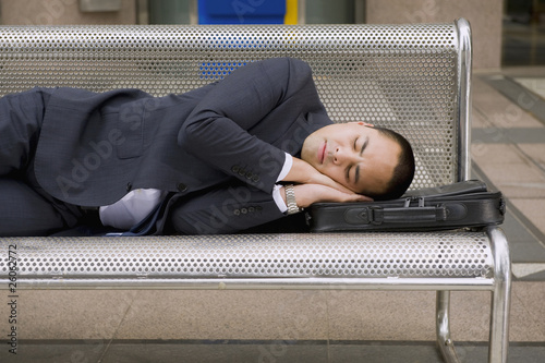 Photo: Mixed race businessman sleeping on bench Mixed race businessman sleeping on bench