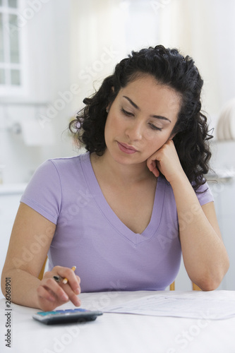 Photo: Hispanic woman calculating taxes Hispanic woman calculating taxes