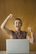 Woman with laptop celebrating