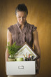 Dejected businesswoman holding box of office belongings