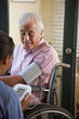 Home nurse taking elderly man's blood pressure