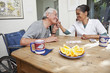 Elderly man holding home nurse's hand