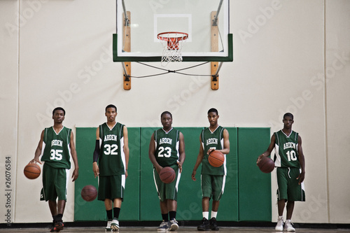 Photo: Serious African basketball players dribbling balls in gym Serious African basketball players dribbling balls in gym