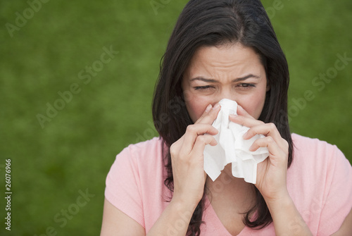 Photo: Hispanic woman blowing nose Hispanic woman blowing nose