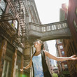 Mixed race woman with arms outstretched on urban street