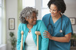 African home nurse helping woman on crutches