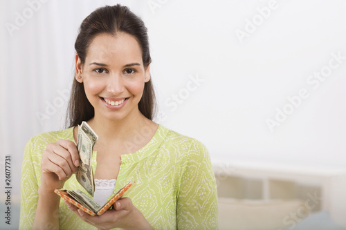 Photo: Hispanic woman removing money from wallet Hispanic woman removing money from wallet
