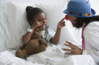 Doctor entertaining girl in hospital bed