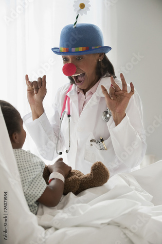 Photo: Doctor entertaining girl in hospital bed Doctor entertaining girl in hospital bed