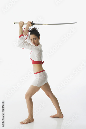 Foto: Mixed race woman performing martial arts with sword Mixed race woman performing martial arts with sword