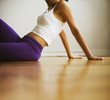 Hispanic woman in sportswear sitting on floor