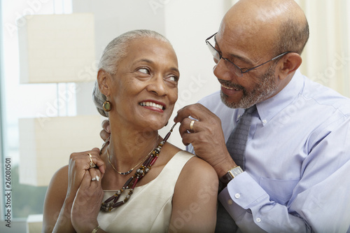 Photo: African man helping wife with necklace African man helping wife with necklace