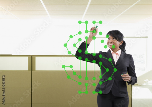 Photo: Mixed race businesswoman drawing dollar sign Mixed race businesswoman drawing dollar sign