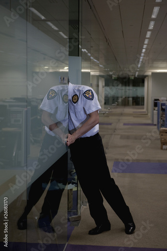 Photo: Hispanic security guard checking office Hispanic security guard checking office